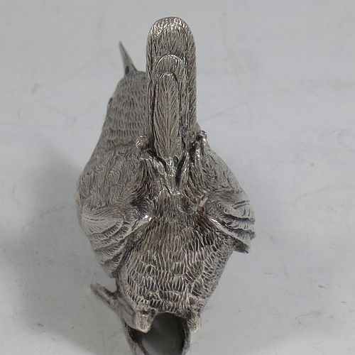 A cast Sterling Silver model of a Wren bird, in a realistic traditional pose, finely detailed with hand-chased body and tail feathers. Made by Robert Glover of London in 1974. The dimensions of this fine hand-made cast sterling silver wren model are length 6 cs (2.3 inches), height 5 cms (2 inches), width 2.5 cms (1 inch), and it weighs approx. 163g (5.25 troy ounces).