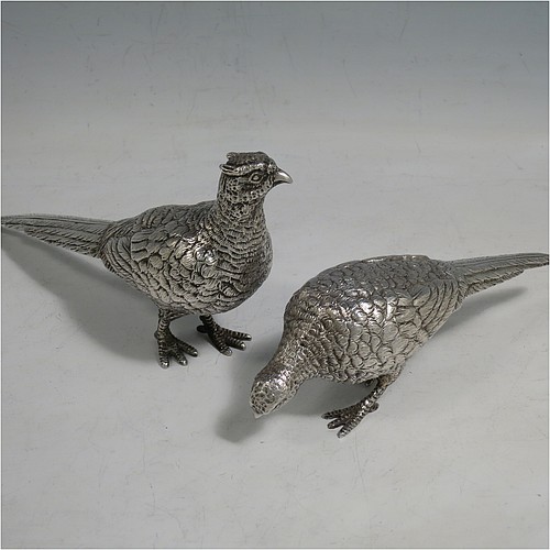 A cast Sterling Silver pair of pheasants, showing a male and female bird in realistic traditional poses, finely detailed with hand-chased bodies and tail feathers. Made by Robert Glover of London in 1973. The dimensions of these fine hand-made sterling silver pheasants are length of male bird 17 cms (6.75 inches), height 8 cms (3 inches), and they weigh a total approx. 310g (10 troy ounces).    