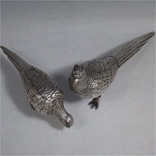 A cast Sterling Silver pair of pheasants, showing a male and female bird in realistic traditional poses, finely detailed with hand-chased bodies and tail feathers. Made by Robert Glover of London in 1973. The dimensions of these fine hand-made sterling silver pheasants are length of male bird 17 cms (6.75 inches), height 8 cms (3 inches), and they weigh a total approx. 310g (10 troy ounces).    