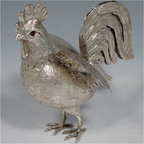 An Antique Edwardian Sterling Silver model of a Rooster or Cockerel bird, having realistically hand-chased feathers, a pull-off head with garnet eyes, with hinged wings, and cast feet. Imported and having hallmarks for Chester in 1903. The dimensions of this fine hand-made antique silver cockerel rooster model are height 14 cms (5.5 inches), length 13 cms (5 inches), width 5.5 cms (2.25 inches), and it weighs approx. 250g (8 troy ounces).