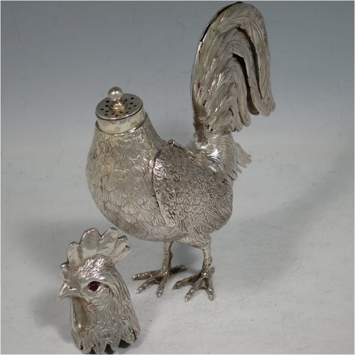 An Antique Edwardian Sterling Silver model of a Rooster or Cockerel bird, having realistically hand-chased feathers, a pull-off head with garnet eyes, with hinged wings, and cast feet. Imported and having hallmarks for Chester in 1903. The dimensions of this fine hand-made antique silver cockerel rooster model are height 14 cms (5.5 inches), length 13 cms (5 inches), width 5.5 cms (2.25 inches), and it weighs approx. 250g (8 troy ounces).