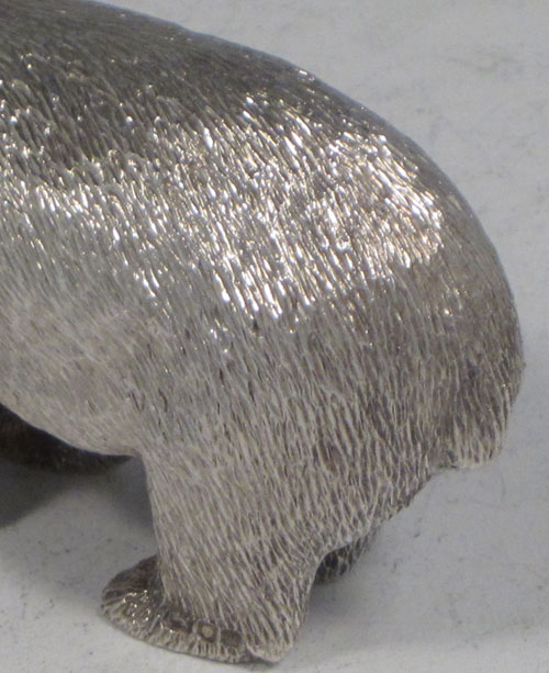 Sterling silver cast model of a standing polar bear, having realistically hand-chased fur, with fine detail. Made by Robert Comyns of London in 1989. The dimensions of this fine hand-made silver polar bear are length 9 cms (3.5 inches), height 4.5 cms (1.75 inches), and it weighs approx. 160g (5.2 troy ounces).
