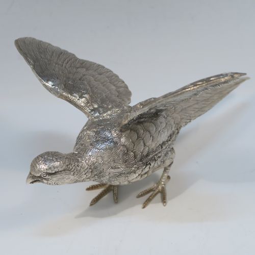 A very handsome Antique Silver-Plated pair of solid cast pheasants, showing a male and female bird in realistic traditional poses, finely detailed with hand-chased bodies and tail feathers. These beautiful silver-plated pheasants were made in ca. 1920. The dimensions of these fine hand-made silver-plated pheasants are length of female bird 28 cms (11 inches), spread across wings 21.5 cms (8.5 inches), and height of male bird to top of head 11 cms (4.3 inches).