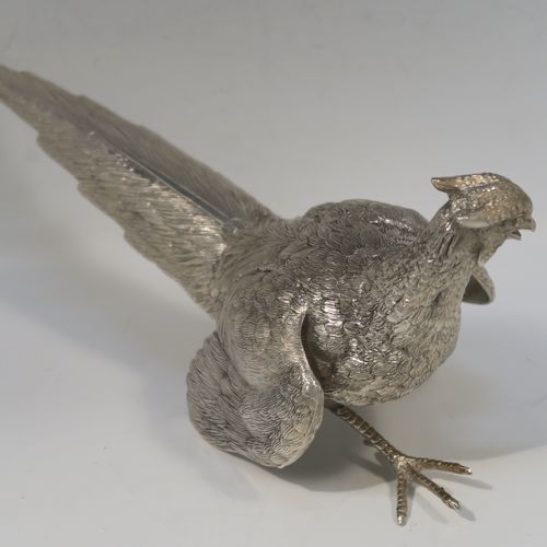 A very handsome Antique Silver-Plated pair of solid cast pheasants, showing a male and female bird in realistic traditional poses, finely detailed with hand-chased bodies and tail feathers. These beautiful silver-plated pheasants were made in ca. 1920. The dimensions of these fine hand-made silver-plated pheasants are length of female bird 28 cms (11 inches), spread across wings 21.5 cms (8.5 inches), and height of male bird to top of head 11 cms (4.3 inches).