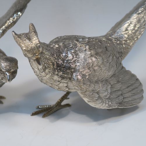 A very handsome Antique Silver-Plated pair of solid cast pheasants, showing a male and female bird in realistic traditional poses, finely detailed with hand-chased bodies and tail feathers. These beautiful silver-plated pheasants were made in ca. 1920. The dimensions of these fine hand-made silver-plated pheasants are length of female bird 28 cms (11 inches), spread across wings 21.5 cms (8.5 inches), and height of male bird to top of head 11 cms (4.3 inches).