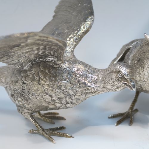 A very handsome Antique Silver-Plated pair of solid cast pheasants, showing a male and female bird in realistic traditional poses, finely detailed with hand-chased bodies and tail feathers. These beautiful silver-plated pheasants were made in ca. 1920. The dimensions of these fine hand-made silver-plated pheasants are length of female bird 28 cms (11 inches), spread across wings 21.5 cms (8.5 inches), and height of male bird to top of head 11 cms (4.3 inches).