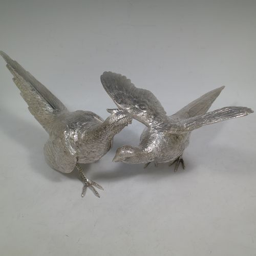 A very handsome Sterling Silver large pair of cast pheasants, showing a male and female bird in realistic traditional poses, finely detailed with hand-chased bodies and tail feathers. Made by C. J. Vanders of London in 2018. The dimensions of these fine hand-made cast sterling silver pheasants are length of male bird 30 cms (11.75 inches), height 14 cms (5.5 inches), and they weigh a total of approx. 2,079g (67 troy ounces).    