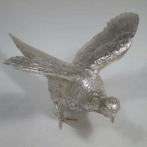 A very handsome Sterling Silver large pair of cast pheasants, showing a male and female bird in realistic traditional poses, finely detailed with hand-chased bodies and tail feathers. Made by C. J. Vanders of London in 2018. The dimensions of these fine hand-made cast sterling silver pheasants are length of male bird 30 cms (11.75 inches), height 14 cms (5.5 inches), and they weigh a total of approx. 2,079g (67 troy ounces).