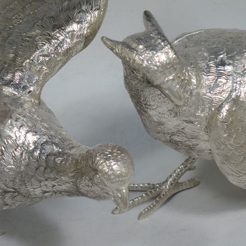 A very handsome Sterling Silver large pair of cast pheasants, showing a male and female bird in realistic traditional poses, finely detailed with hand-chased bodies and tail feathers. Made by C. J. Vanders of London in 2018. The dimensions of these fine hand-made cast sterling silver pheasants are length of male bird 30 cms (11.75 inches), height 14 cms (5.5 inches), and they weigh a total of approx. 2,079g (67 troy ounces).