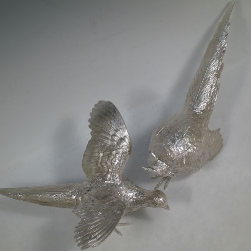 A very handsome Sterling Silver large pair of cast pheasants, showing a male and female bird in realistic traditional poses, finely detailed with hand-chased bodies and tail feathers. Made by C. J. Vanders of London in 2018. The dimensions of these fine hand-made cast sterling silver pheasants are length of male bird 30 cms (11.75 inches), height 14 cms (5.5 inches), and they weigh a total of approx. 2,079g (67 troy ounces).