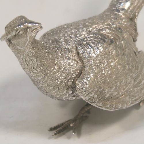 A very handsome Sterling Silver pair of solid cast pheasants, showing a male and female bird in realistic traditional poses, finely detailed with hand-chased bodies and tail feathers. These beautiful silver pheasants were made by C. J. Vander of Sheffield in 1995. The dimensions of these fine hand-made sterling silver pheasants are length of female bird 13.5 cms (5.25 inches), spread across wings 8 cms (6 inches), height of male bird to top of head 6 cms (2.3 inches), and they weigh a total approx. 305g (9.8 troy ounces).