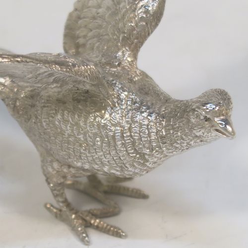 A very handsome Sterling Silver pair of solid cast pheasants, showing a male and female bird in realistic traditional poses, finely detailed with hand-chased bodies and tail feathers. These beautiful silver pheasants were made by C. J. Vander of Sheffield in 1995. The dimensions of these fine hand-made sterling silver pheasants are length of female bird 13.5 cms (5.25 inches), spread across wings 8 cms (6 inches), height of male bird to top of head 6 cms (2.3 inches), and they weigh a total approx. 305g (9.8 troy ounces).