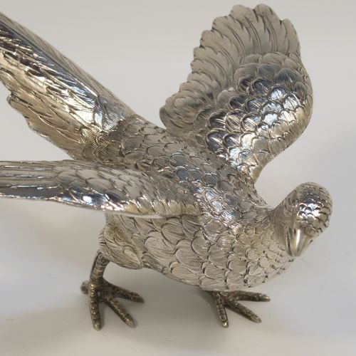 A very handsome Sterling Silver pair of solid cast pheasants, showing a male and female bird in realistic traditional poses, finely detailed with hand-chased bodies and tail feathers. These beautiful silver pheasants were made by I. Freeman of London in 1974. The dimensions of these fine hand-made sterling silver pheasants are length of female bird 19 cms (7.5 inches), spread across wings 12 cms (4.75 inches), height of male bird to top of head 9 cms (3.5 inches), and they weigh a total approx. 320g (10.3 troy ounces).