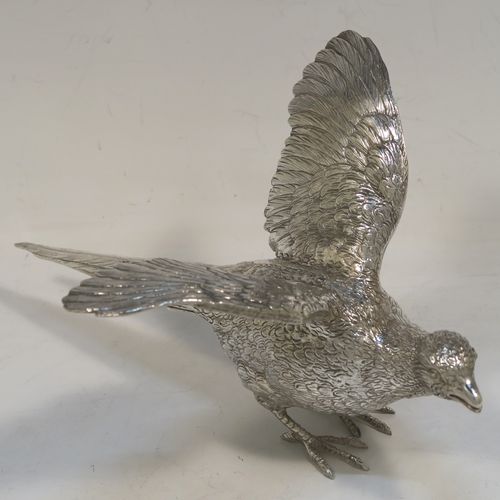 A very handsome Sterling Silver pair of cast pheasants, showing a male and female bird in realistic traditional poses, finely detailed with hand-chased bodies and tail feathers. These beautiful silver pheasants were made by D. J. Silver of London in 1972. The dimensions of these fine hand-made sterling silver pheasants are length of female bird 23 cms (9 inches), spread across wings 15 cms (6 inches), height of male bird to top of head 8 cms (3 inches), and they weigh a total approx. 815g (26.3 troy ounces).