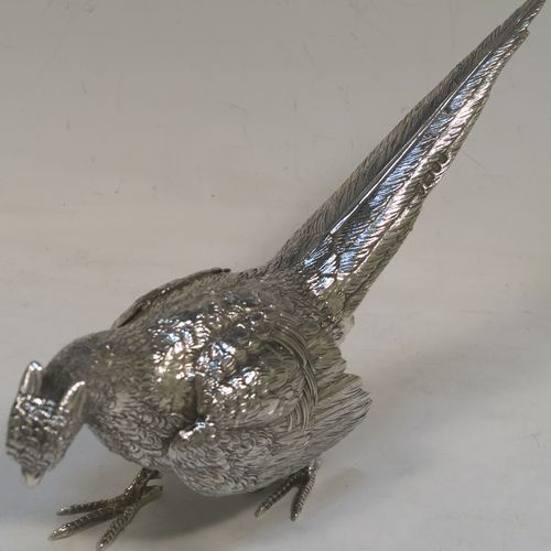 A very handsome Sterling Silver pair of cast pheasants, showing a male and female bird in realistic traditional poses, finely detailed with hand-chased bodies and tail feathers. These beautiful silver pheasants were made by D. J. Silver of London in 1972. The dimensions of these fine hand-made sterling silver pheasants are length of female bird 23 cms (9 inches), spread across wings 15 cms (6 inches), height of male bird to top of head 8 cms (3 inches), and they weigh a total approx. 815g (26.3 troy ounces).