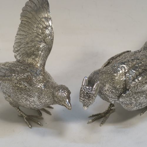A very handsome Sterling Silver pair of cast pheasants, showing a male and female bird in realistic traditional poses, finely detailed with hand-chased bodies and tail feathers. These beautiful silver pheasants were made by D. J. Silver of London in 1972. The dimensions of these fine hand-made sterling silver pheasants are length of female bird 23 cms (9 inches), spread across wings 15 cms (6 inches), height of male bird to top of head 8 cms (3 inches), and they weigh a total approx. 815g (26.3 troy ounces).
