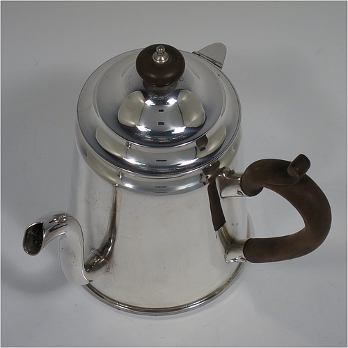 An Antique Edwardian Silver Plated Argyll, having a plain round body with tapering sides and applied reeded borders, a stepped pull-off lid with wooden finial, a scroll pouring spout, a wooden scroll handle, a separate side spout with hinged lid for adding hot water to the water jacket, and all sitting on a flat base. Made in ca. 1910. The dimensions of this fine hand-made antique silver-plated Argyll are height 15 cms (6 inches), diameter at base 10 cms (4 inches), and length across spouts 15 cms (6 inches).
