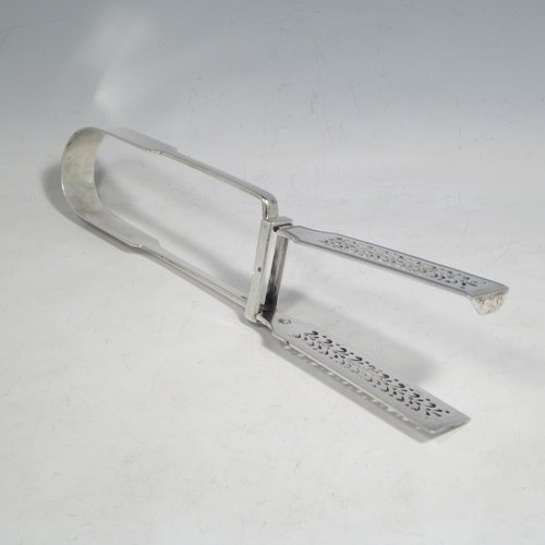 Antique Georgian sterling silver Fiddle pattern pair of asparagus serving tongs, having hand-pierced blades, and original retaining guard with screws. Made by William Eley of London in 1828. The dimensions of this fine hand-made silver pair of asparagus tongs are length 24 cms (9.5 inches), and it weighs approx. 162g (5.2 troy ounces). Please note that this item is crested.   