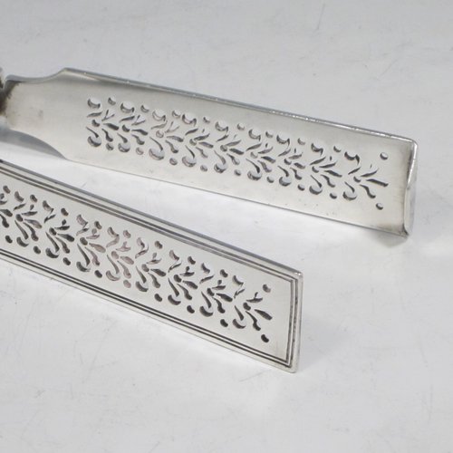 Antique Georgian sterling silver Fiddle pattern pair of asparagus serving tongs, having hand-pierced blades, and original retaining guard with screws. Made by William Eley of London in 1828. The dimensions of this fine hand-made silver pair of asparagus tongs are length 24 cms (9.5 inches), and it weighs approx. 162g (5.2 troy ounces). Please note that this item is crested.