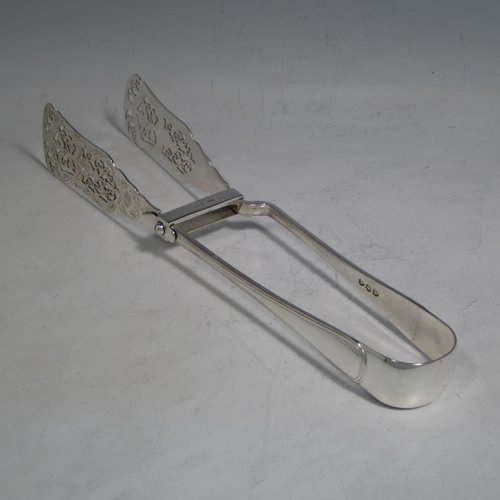 An Antique Victorian sterling silver Old English Thread pattern pair of pretty asparagus serving tongs, having hand-pierced blades with floral decoration, and original retaining guard with screw. Made by Edward Hutton of London in 1892. The dimensions of this fine pair of antique silver asparagus servers are length 24 cms (9.5 inches), and they weigh approx. 151g (4.9 troy ounces).   