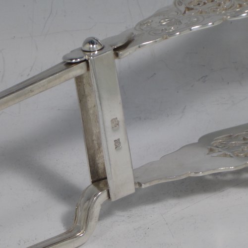 An Antique Victorian sterling silver Old English Thread pattern pair of pretty asparagus serving tongs, having hand-pierced blades with floral decoration, and original retaining guard with screw. Made by Edward Hutton of London in 1892. The dimensions of this fine pair of antique silver asparagus servers are length 24 cms (9.5 inches), and they weigh approx. 151g (4.9 troy ounces).