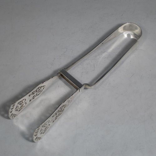 An Antique Victorian sterling silver Old English Thread pattern pair of pretty asparagus serving tongs, having hand-pierced blades with floral decoration, and original retaining guard with screw. Made by Edward Hutton of London in 1892. The dimensions of this fine pair of antique silver asparagus servers are length 24 cms (9.5 inches), and they weigh approx. 151g (4.9 troy ounces).