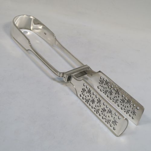 A very handsome and crisp Antique Victorian Sterling Silver Fiddle and Thread pattern pair of asparagus serving tongs, having hand-pierced blades, and an original retaining guard with screws. This elegant antique silver pair of asparagus tongs was made by William Smily of London in 1855. The dimensions of this fine pair of antique silver asparagus servers are length 26 cms (10.25 inches), and they weigh approx. 186g (6 troy ounces). Please note that this item is part crested.   