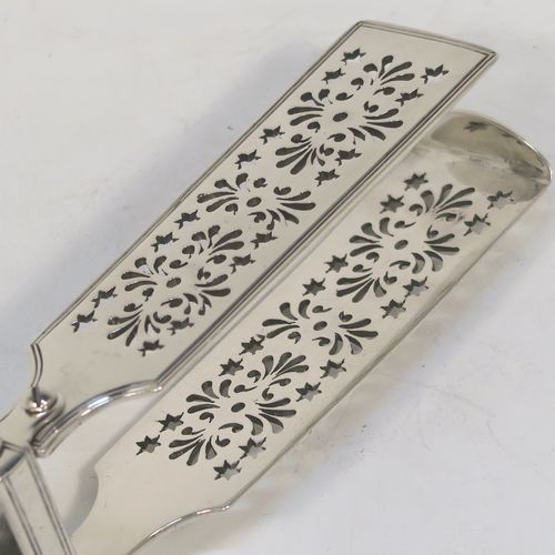 A very handsome and crisp Antique Victorian Sterling Silver Fiddle and Thread pattern pair of asparagus serving tongs, having hand-pierced blades, and an original retaining guard with screws. This elegant antique silver pair of asparagus tongs was made by William Smily of London in 1855. The dimensions of this fine pair of antique silver asparagus servers are length 26 cms (10.25 inches), and they weigh approx. 186g (6 troy ounces). Please note that this item is part crested.