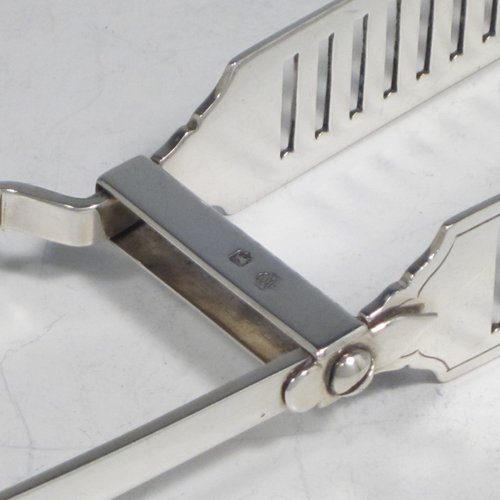 Antique Victorian sterling silver Old English pattern pair of asparagus serving tongs, having hand-pierced blades, and original retaining guard with screws. Made by William Hutton of London in 1895. The dimensions of this fine pair of antique silver asparagus servers are length 22.5 cms (8.75 inches), and they weigh approx. 122g (4 troy ounces).
