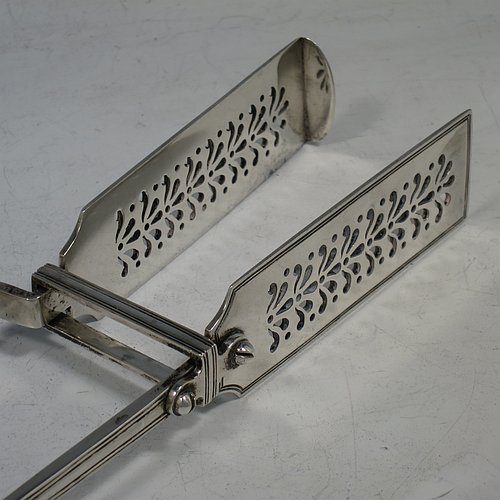 An Antique Victorian Sterling Silver pair of asparagus serving tongs, in the Fiddle, Thread, & Shell pattern, having hand-pierced blades, and original retaining guard with screws. Made by George Adams of London in 1856. The dimensions of this fine pair of antique silver asparagus servers are length 25 cms (9.75 inches), and they weigh approx. 223g (7.2 troy ounces). Please note that this item is crested.