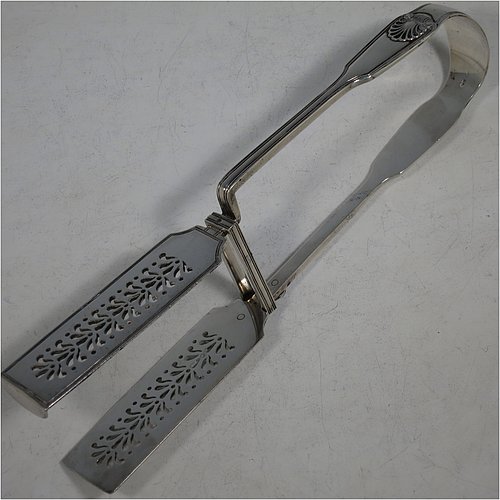 An Antique Victorian Sterling Silver pair of asparagus serving tongs, in the Fiddle, Thread, & Shell pattern, having hand-pierced blades, and original retaining guard with screws. Made by George Adams of London in 1856. The dimensions of this fine pair of antique silver asparagus servers are length 25 cms (9.75 inches), and they weigh approx. 223g (7.2 troy ounces). Please note that this item is crested.