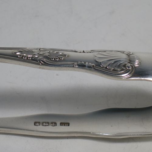 A handsome Sterling Silver pair of asparagus serving tongs, in the Kings pattern, having plain hand-pierced blades, and original retaining guard with screw. Made by George Hancock of Sheffield in 1928. The dimensions of this fine pair of silver asparagus servers are length 19 cms (7.5 inches), and they weigh approx. 148g (4.8 troy ounces).