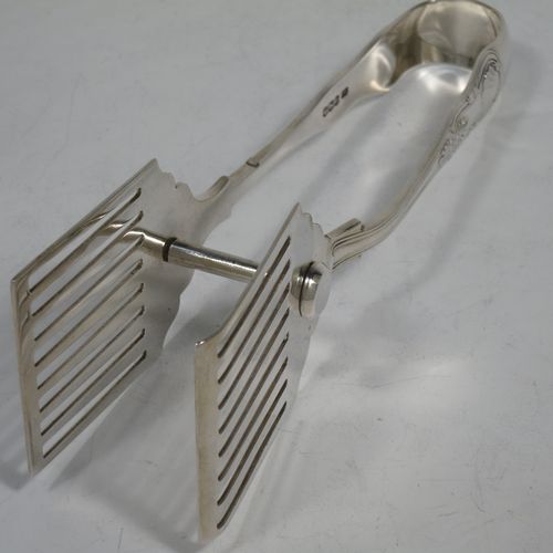 A handsome Sterling Silver pair of asparagus serving tongs, in the Kings pattern, having plain hand-pierced blades, and original retaining guard with screw. Made by George Hancock of Sheffield in 1928. The dimensions of this fine pair of silver asparagus servers are length 19 cms (7.5 inches), and they weigh approx. 148g (4.8 troy ounces).
