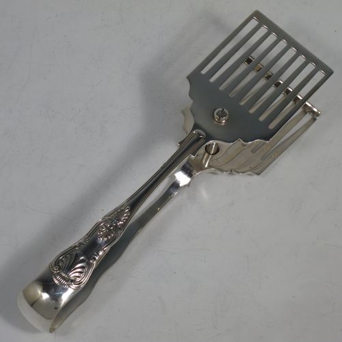 A handsome Sterling Silver pair of asparagus serving tongs, in the Kings pattern, having plain hand-pierced blades, and original retaining guard with screw. Made by George Hancock of Sheffield in 1928. The dimensions of this fine pair of silver asparagus servers are length 19 cms (7.5 inches), and they weigh approx. 148g (4.8 troy ounces).