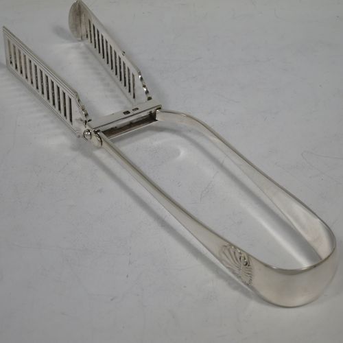 A handsome Antique Victorian Sterling Silver pair of large asparagus serving tongs, in the Old English and Shell pattern, having hand-pierced blades with hand-engraved reeded decoration, and original retaining guard with screw. Made by George Hancock of Sheffield in 1901. The dimensions of this fine hand-made pair of antique silver asparagus servers are length 23 cms (9 inches), and they weigh approx. 142g (4.5 troy ounces).    