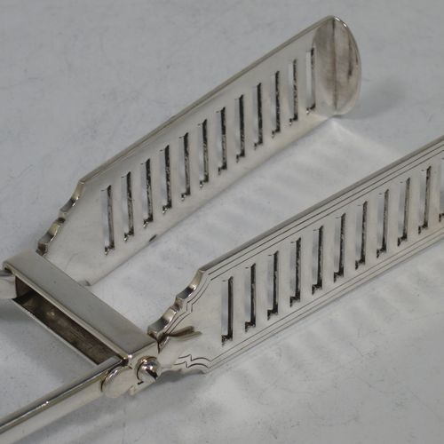 A handsome Antique Victorian Sterling Silver pair of large asparagus serving tongs, in the Old English and Shell pattern, having hand-pierced blades with hand-engraved reeded decoration, and original retaining guard with screw. Made by George Hancock of Sheffield in 1901. The dimensions of this fine hand-made pair of antique silver asparagus servers are length 23 cms (9 inches), and they weigh approx. 142g (4.5 troy ounces).
