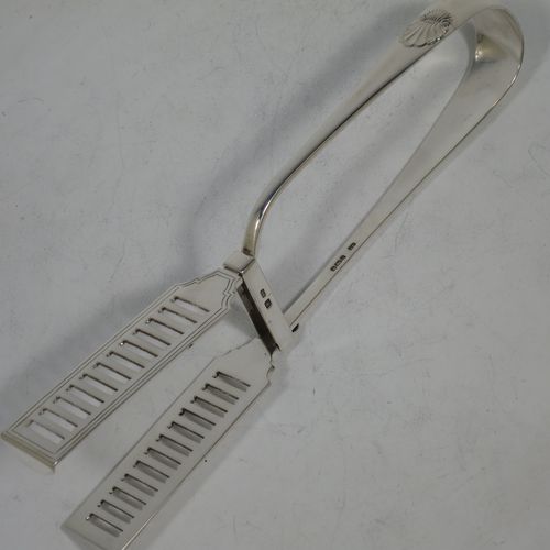 A handsome Antique Victorian Sterling Silver pair of large asparagus serving tongs, in the Old English and Shell pattern, having hand-pierced blades with hand-engraved reeded decoration, and original retaining guard with screw. Made by George Hancock of Sheffield in 1901. The dimensions of this fine hand-made pair of antique silver asparagus servers are length 23 cms (9 inches), and they weigh approx. 142g (4.5 troy ounces).