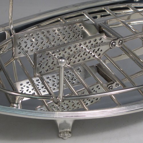 Antique Edwardian silver plated asparagus serving set, having a plain oval body, with an applied reeded border, an original wire-work serving rack, two cut-out side-handles, and sitting on four cast flange feet. Together with a matching pair of tongs made by John Grinsell of Sheffield in ca. 1900. The dimensions of this fine hand-made silver-plated asparagus serving set are length 43 cms (17 inches), and width, 21.5 cms (8.5 inches).