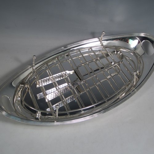 Antique Edwardian silver plated asparagus serving set, having a plain oval body, with an applied reeded border, an original wire-work serving rack, two cut-out side-handles, and sitting on four cast flange feet. Together with a matching pair of tongs made by John Grinsell of Sheffield in ca. 1900. The dimensions of this fine hand-made silver-plated asparagus serving set are length 43 cms (17 inches), and width, 21.5 cms (8.5 inches).