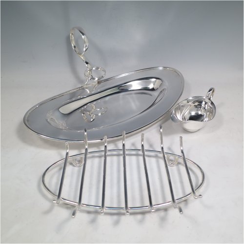 An Antique Edwardian Silver Plated asparagus serving set, having a plain oval body, with an applied rounded border, an original wire-work serving rack, a sauce boat sat in a frame with loop handle, and all sitting on a flat base. Made by Charles Green & Co., of Sheffield in ca. 1900. The dimensions of this fine hand-made silver-plated asparagus serving set are length 34 cms (13.5 inches), and width, 19 cms (7.5 inches).