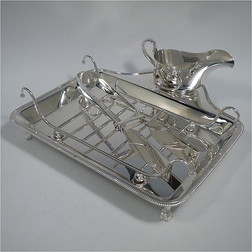 An Antique Edwardian Silver Plated asparagus serving set, having a plain rectangular body, with an applied gadroon border, a wire-work serving rack, a sauce boat sat in a frame with loop handle, a pair of asparagus server tongs, and all sitting on a base with four cast trefoil feet. All pieces were made by Mappin and Webb of London in ca. 1900. The dimensions of this fine hand-made antique silver-plated asparagus serving set are length 26.5 cms (10.5 inches), and width, 25.5 cms (10 inches).