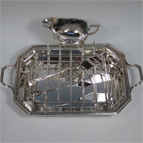 An Art Deco style Silver Plated asparagus serving set, having a plain elongated octagonal body, with an applied reeded border and two cast side-handles, a wire-work serving rack, a sauce boat sat in a frame with loop handle, a pair of asparagus server tongs, and all sitting on a flat base. All pieces are original and were made in England, circa 1930. The dimensions of this fine hand-made silver-plated Art Deco asparagus serving set are length 32.5 cms (12.75 inches), and width, 20 cms (8 inches).