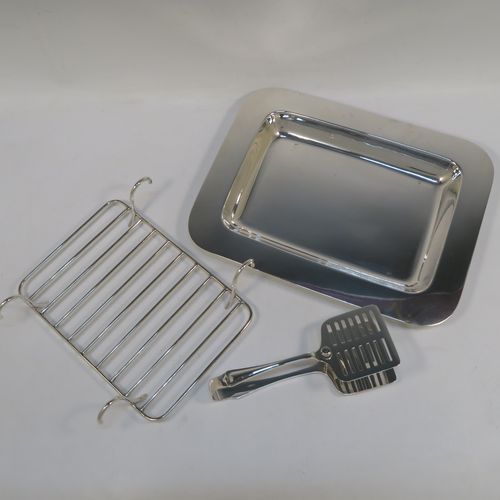 An Antique Edwardian Silver Plated asparagus serving set, having a plain rectangular body, with a wire-work serving rack, and a pair of asparagus server tongs, and all sitting on a flat base. This beautiful asparagus server set was made by the Atkins Brothers of Sheffield in ca. 1910. The dimensions of this fine hand-made silver-plated asparagus serving set are length 30.5 cms (12 inches), and width, 24 cms (9.5 inches). Please note that the asparagus servers are monogrammed, and the base has very light scratches, but everything else is in very good original condition, with no plate wearing off.