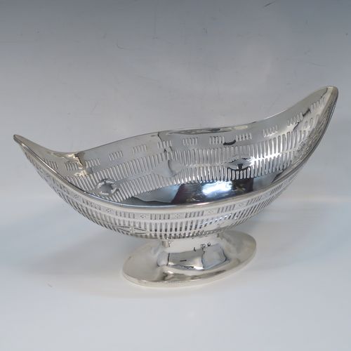 A beautiful Antique Georgian Irish Sterling Silver bread or fruit basket, having an oval body with hand-pierced neoclassical and geometrical style  decoration, an applied reeded border, and all sitting on a plain oval pedestal foot. This pretty antique silver fruit or bread basket was made by Michael Homer of Dublin, Ireland, in ca. 1790. The dimensions of this fine hand-made Irish Georgian silver basket are length 30 cms (11.75 inches), width 15 cms (6 inches), height 15 cms (6 inches), and it weighs approx. 410g (13.2 troy ounces).   