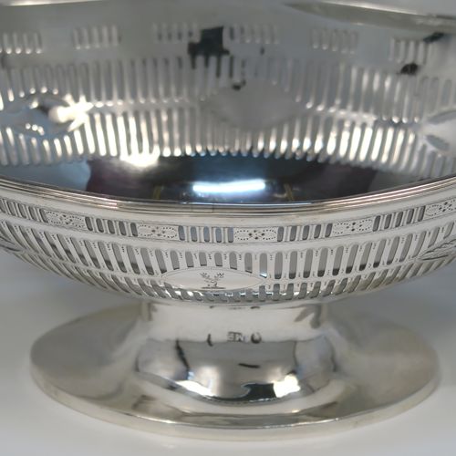 A beautiful Antique Georgian Irish Sterling Silver bread or fruit basket, having an oval body with hand-pierced neoclassical and geometrical style  decoration, an applied reeded border, and all sitting on a plain oval pedestal foot. This pretty antique silver fruit or bread basket was made by Michael Homer of Dublin, Ireland, in ca. 1790. The dimensions of this fine hand-made Irish Georgian silver basket are length 30 cms (11.75 inches), width 15 cms (6 inches), height 15 cms (6 inches), and it weighs approx. 410g (13.2 troy ounces).   