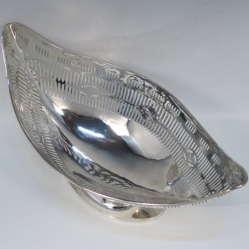 A beautiful Antique Georgian Irish Sterling Silver bread or fruit basket, having an oval body with hand-pierced neoclassical and geometrical style  decoration, an applied reeded border, and all sitting on a plain oval pedestal foot. This pretty antique silver fruit or bread basket was made by Michael Homer of Dublin, Ireland, in ca. 1790. The dimensions of this fine hand-made Irish Georgian silver basket are length 30 cms (11.75 inches), width 15 cms (6 inches), height 15 cms (6 inches), and it weighs approx. 410g (13.2 troy ounces).   
