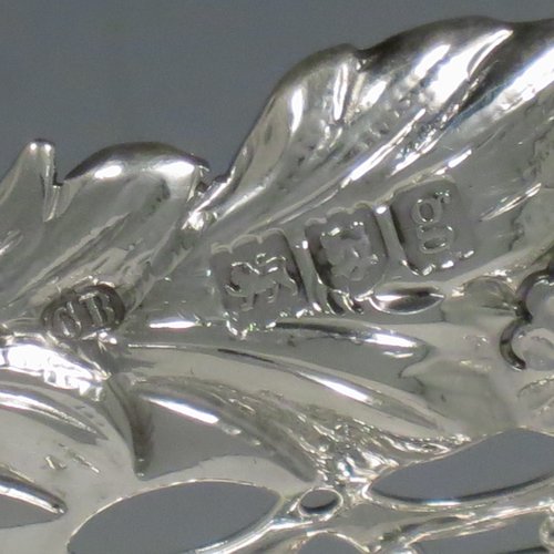 An Antique Edwardian pair of Sterling silver table baskets, having oval bodies with hand-pierced scroll-work decoration, with hand-chased floral borders, and sitting on matching pierced & scroll feet. Made by Charles Boyton of London in 1902. The dimensions of this fine pair of antique silver baskets are length 27 cms (10.75 inches), width 18.5 cms (7.25 inches), height 9 cms (3.5 inches), and they weigh a total of approx. 586g (19 troy ounces).