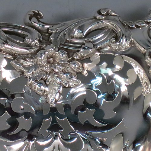 An Antique early Victorian large Sterling Silver table basket, having a round body with hand-pierced floral decoration within melon fluted panels, an applied cast floral and scroll border, and sitting on a melon fluted pedestal foot. Made by the Barnard Brothers of London in 1845. The dimensions of this fine hand-made antique silver basket are diameter 36 cms (14.25 inches), height 11 cms (4.25 inches), and it weighs approx. 1,082g (35 troy ounces).