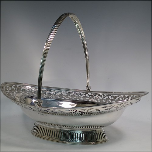 A very pretty Antique Georgian Sterling Silver basket, having an oval body with an applied reeded border, with an upper band of hand-engraved and hand-pierced floral work, a hinged and reeded swing handle, all sitting on a geometrically hand-pierced collet foot. Made by Thomas Harper I of London in 1796. The dimensions of this fine hand-made antique silver basket are height 28 cms (11 inches), length 37 cms (14.5 inches), width 26 cms (10.25 inches), and it weighs approx. 792g (25.5 troy ounces). Please note that this basket is crested.