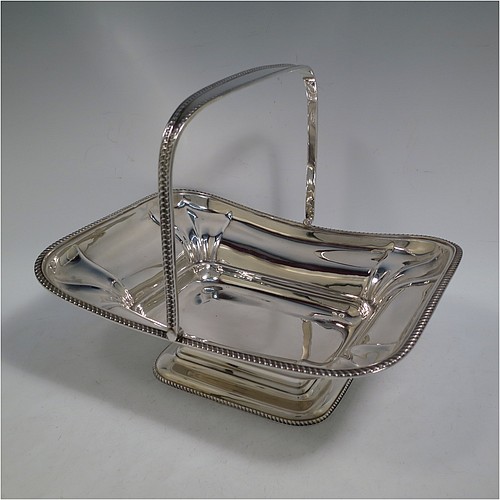 An Antique Edwardian Sterling Silver basket, having a rectangular body, with an applied gadroon border, a hinged and swing handle with gadroon edges, all sitting on a pedestal foot. Made by the Dixon Brothers of Sheffield in 1910. The dimensions of this fine hand-made antique silver basket are height 23 cms (9 inches), length 27.5 cms (10.75 inches), width 21 cms (8.25 inches), and it weighs approx. 746g (24 troy ounces).    